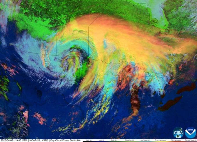 Satellite image of a large storm system stretching across central North America observed on April 8, 2026, with a swirl centered over the western United States and broad cloud bands extending into the Plains, Great Lakes, and southern Canada. The enhanced-color day cloud phase view shows cloud patterns in shades of blue, yellow, orange, and red. NOAA and CIRA logos appear in the lower-right corner.