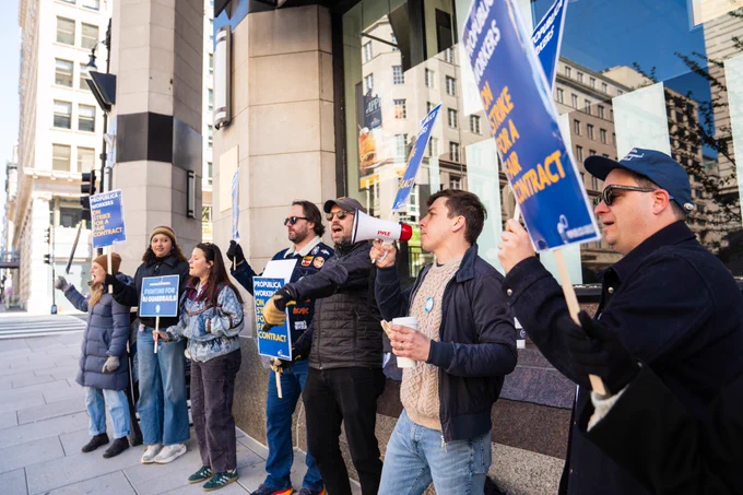 Seven people hold blue signs that say "ProPublica workers on strike for a fair contract."