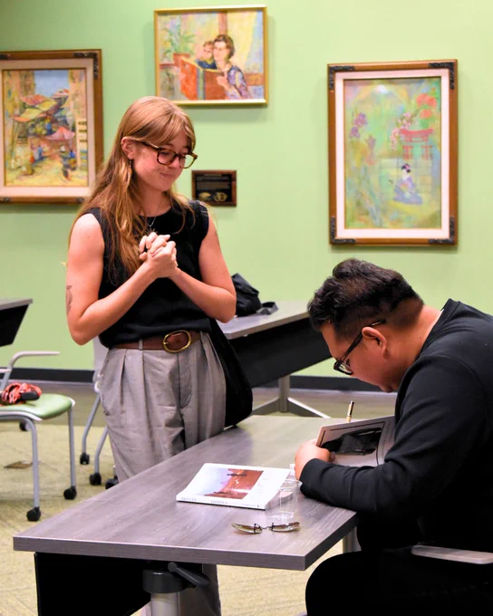 Jake Skeets signing a student's book