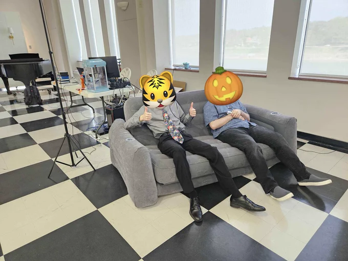 200Tigersbloxed and Virtual sitting on an inflatable couch wearing the two VR headsets after setting up the demo.
