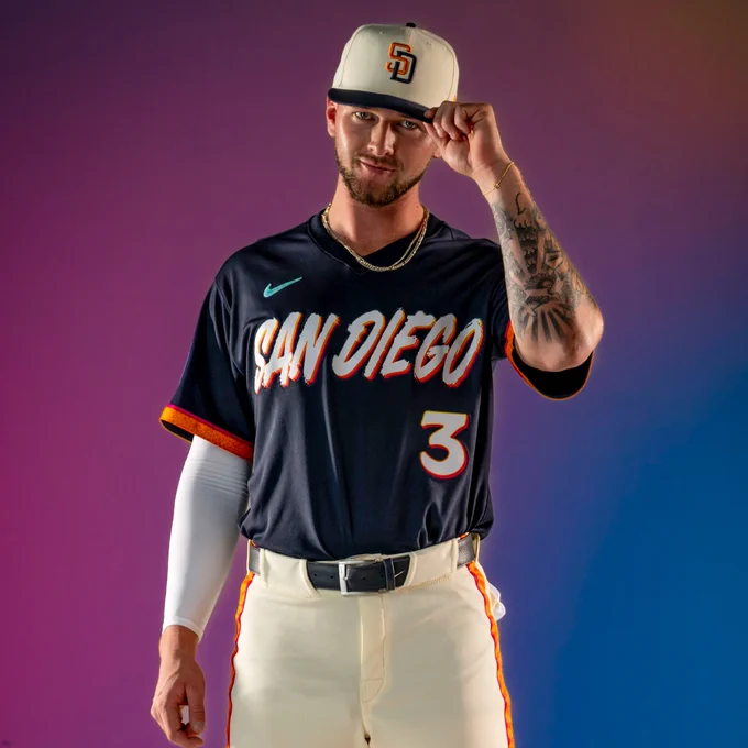Jackson Merrill posing for a photo in the new Padres City Connect uniform. He’s grabbing the brim of his hat with his left hand.
