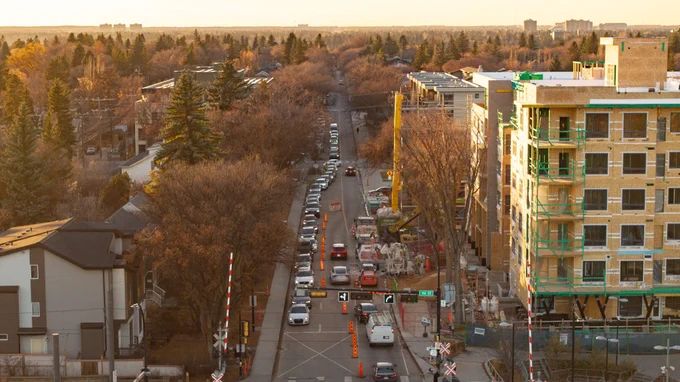 An aerial view of a busy Edmonton street at rush hour, showing multiple lanes of traffic and nearby buildings.