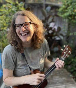 An image of the namesake of the award, Karen Sokohl, smiling and playing a string instrument.