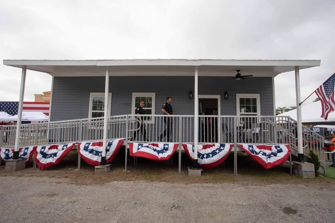 a small grey home with bunting and a usa flag 