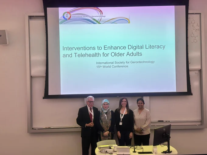 Presenters Paul Fredolino, Siti Mazidah Mohamad, Elena Remillard, and Raksha Mudar stand in front of a slide at the #ISG2026 symposium.
