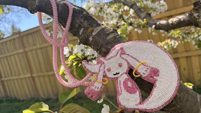 Finally finished this beaded Kyubey medallion. This is the little wish granting creature from Puella Magi Madako Magica, which looks like a white cat with extra long floppy ears. It has light pink eyes, ear tips and O on its back. The necklace is odd count peyote stitched with pink and white beads.