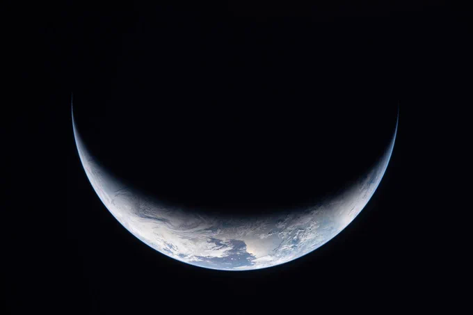  A sliver of Earth is illuminated against the blackness of space in this photo taken by an Artemis II crew member through an Orion spacecraft window on the third day of the mission. Credit: NASA