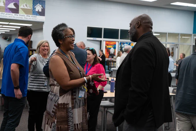 A staff member talking with the new principal at Wren High School