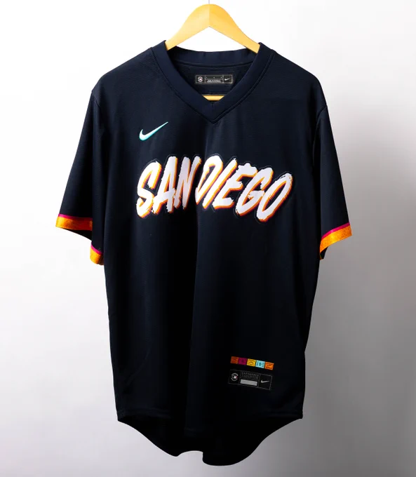 A black San Diego Padres City Connect jersey with white and orange lettering.