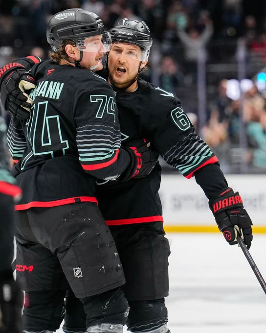 a photo of Seattle Kraken defender Brandon Montour embracing forward Bobby McMann.