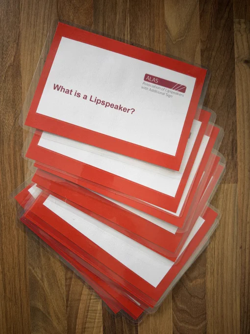 A stack of red and white information cards stacked on a worktop. The cards have all been laminated.