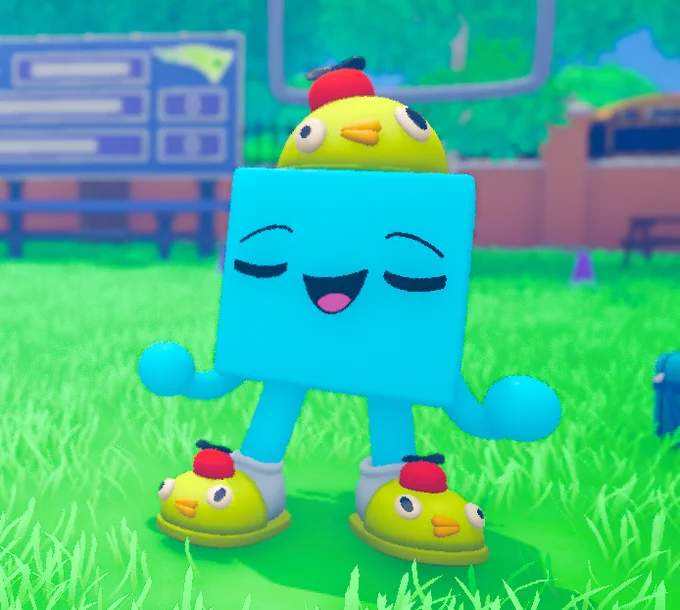 A blue cube-shaped character with a smiling face stands on grass, wearing bright yellow slippers and a matching hat shaped like a small yellow creature, eyes closed in a relaxed pose.