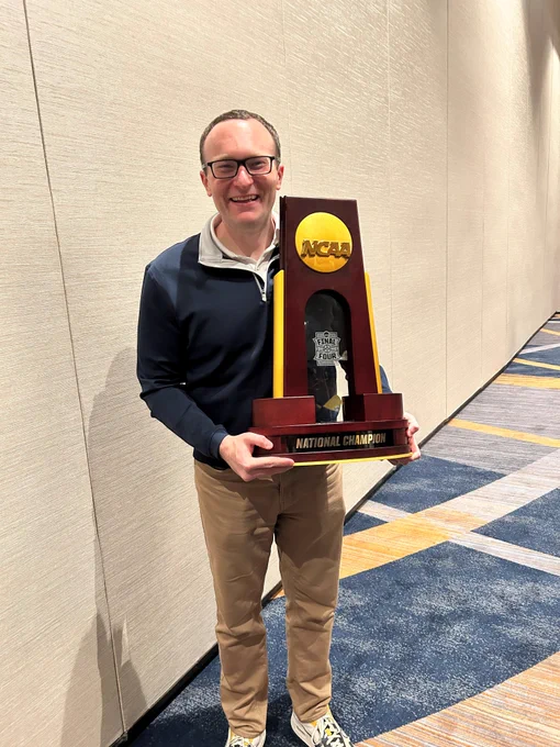 Brian Boesch poses with the NCAA Men's Basketball Championship trophy.