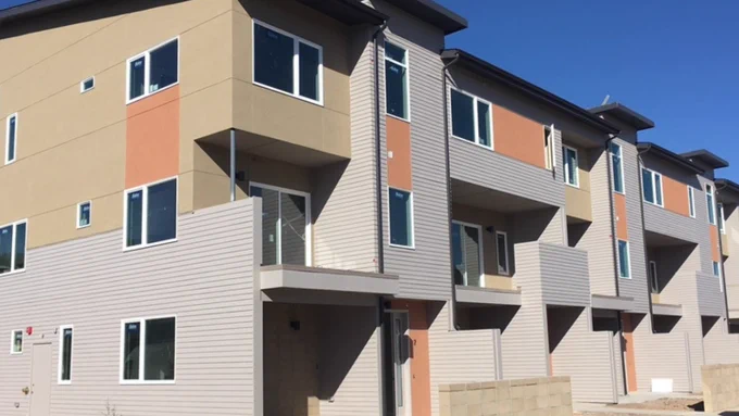 A new apartment building with gray and orange panels.