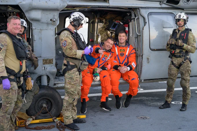 NASA astronaut Reid Wiseman, Artemis II commander, left, and CSA (Canadian Space Agency) astronaut Jeremy Hansen, Artemis II mission specialist, are seen sitting on a Navy MH-60 Seahawk from Helicopter Sea Combat Squadron (HSC) 23 on the flight deck of USS John P. Murtha after they and fellow crewmates NASA astronaut Christina Koch, Artemis II mission specialist, and NASA astronaut Victor Glover, Artemis II pilot, were extracted from their Orion spacecraft after splashdown, Friday, April 10, 2026, in the Pacific Ocean off the coast of California. NASA\u2019s Artemis II mission took the quartet on a nearly 10-day journey around the Moon and back to Earth. Following a splashdown at 5:07 p.m. PDT (8:07 p.m. EDT), NASA, U.S. Navy, and U.S. Air Force teams are working to bring the Orion spacecraft aboard the recovery ship. Credit: NASA/Bill Ingalls