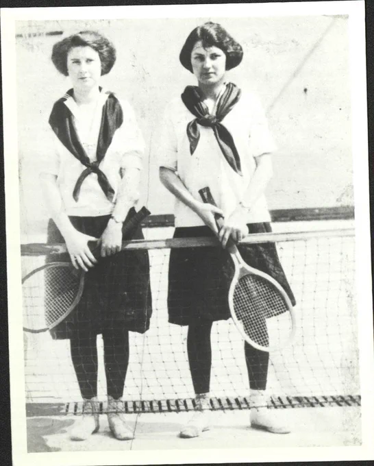 Two female students wearing bloomers and big white blouses and holding tennis rackets, circa 1925. From University Archives.