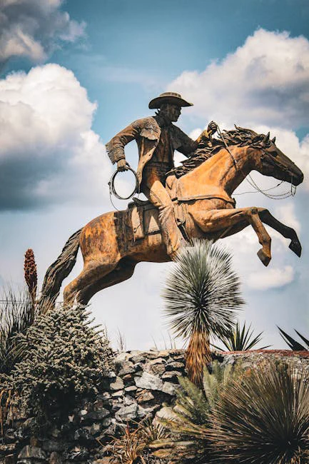 Dynamic cowboy statue on horseback set against a vibrant blue sky in Tamps., México.