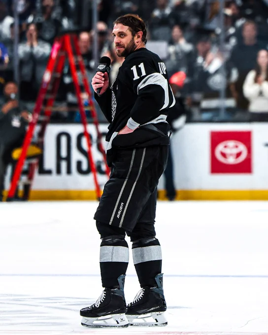 Anze Kopitar speaking to the Kings' crowd on a mic in a Kings uniform. 