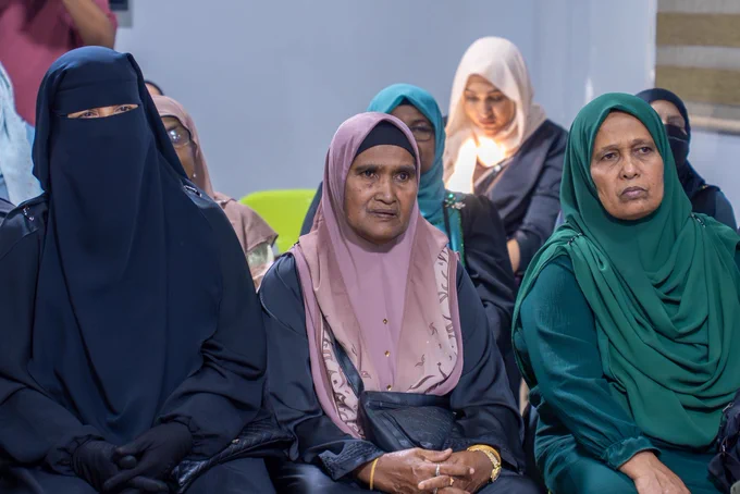 Picture of elderly women sitting down and listening to a speaker