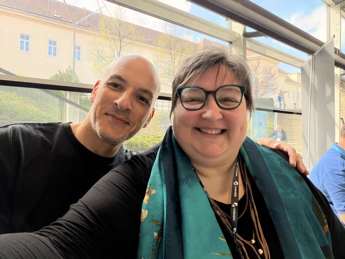 A middle-aged man and a middle-aged woman taking a selfie with smiling faces