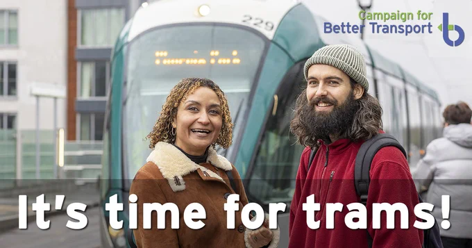 Photo of two people smiling near a tram with the words "It's time for trams!"