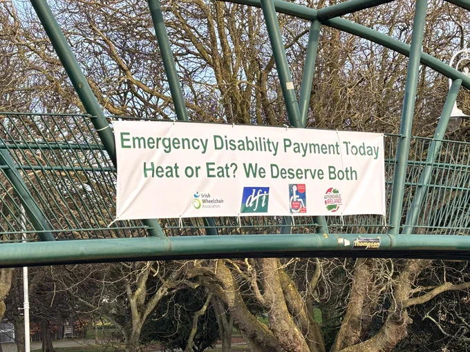 Image of a banner on a bridge asking for an emergency Disabilty payment to heat or eat.