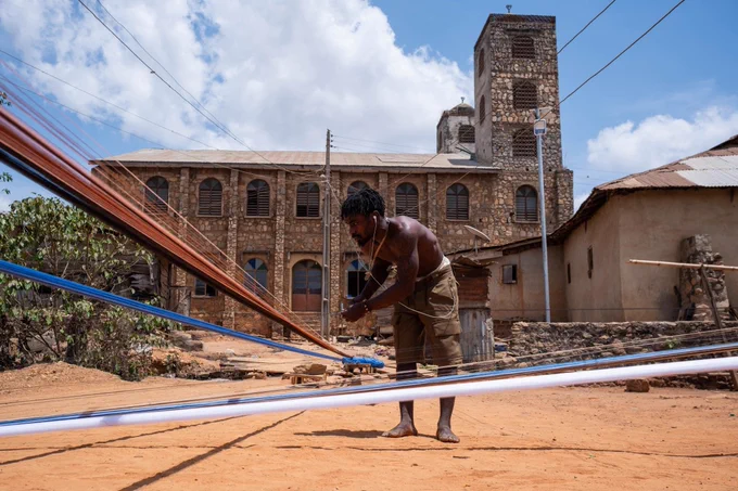 Waliu Fransisco separates tangled thread used for aso-oke, a handwoven fabric indigenous to the Yoruba ethnic group. [Toyin Adedokun/AFP]