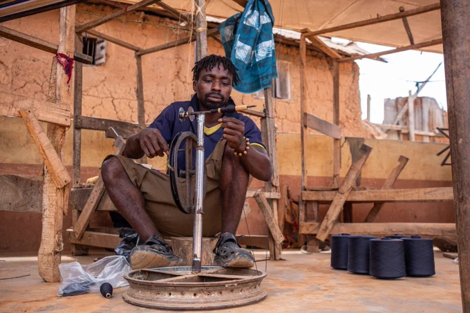 While many weavers in Iseyin are middle-aged men, younger artisans like Fransisco are joining the trade, introducing fresh ideas and skills. [Toyin Adedokun/AFP]