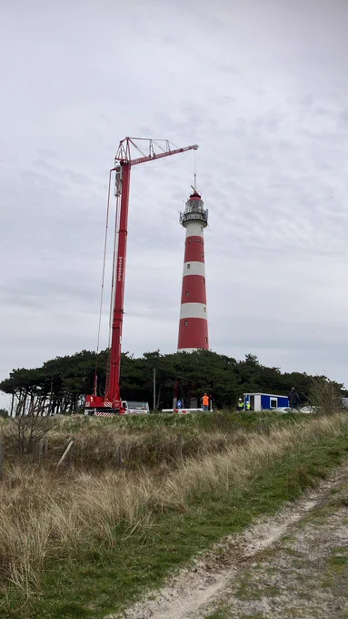 De radarsensor op de vuurtoren van Ameland wordt vervangen. Doormiddel van een kraan wordt de oude radarsensor eraf gehaald. 