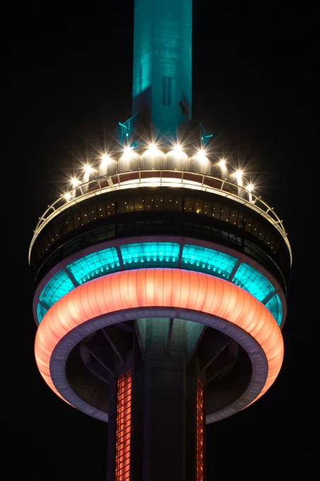 Closeup of the CNTower at night lit blue and orange / Gros plan de la Tour CN illuminée en bleu et orange la nuit 