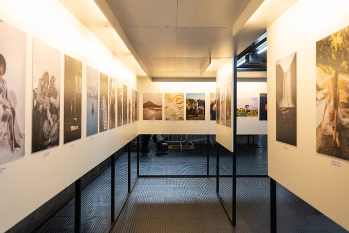 A well-lit art exhibition featuring diverse photographic prints in a modern indoor gallery.