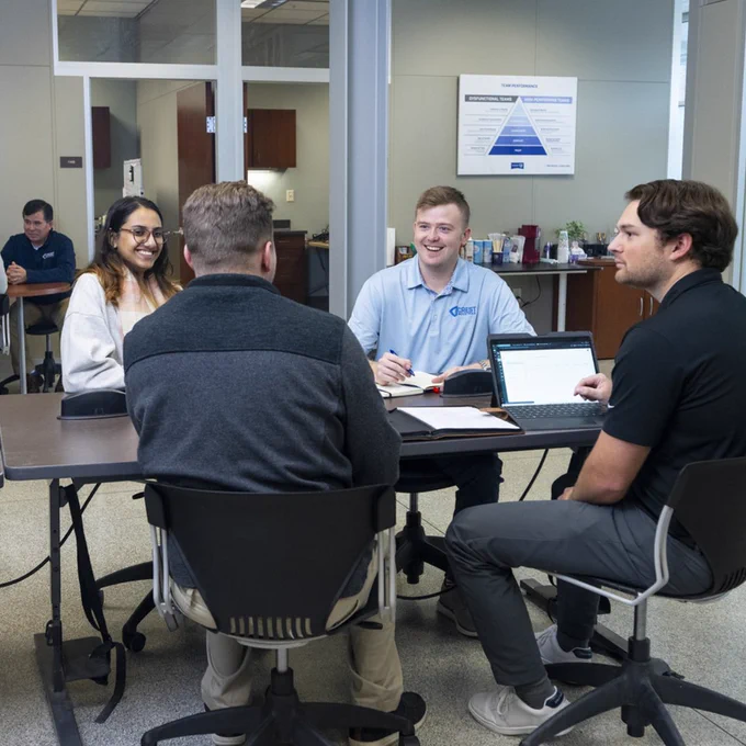 Joshua Nelson, Daylon Bozeman, and other Crest employees gathered at an office table