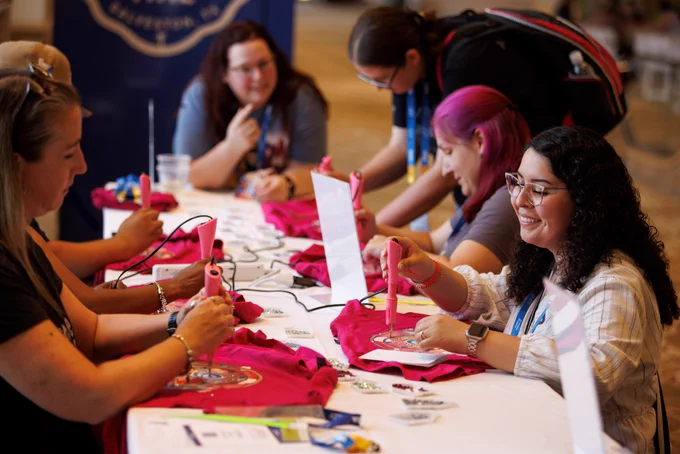 Photo of a group of people at a table doing arts and crafts. 