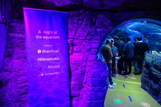 An event banner highlights “A night at the aquarium,” while guests explore an underwater tunnel with vibrant lighting.