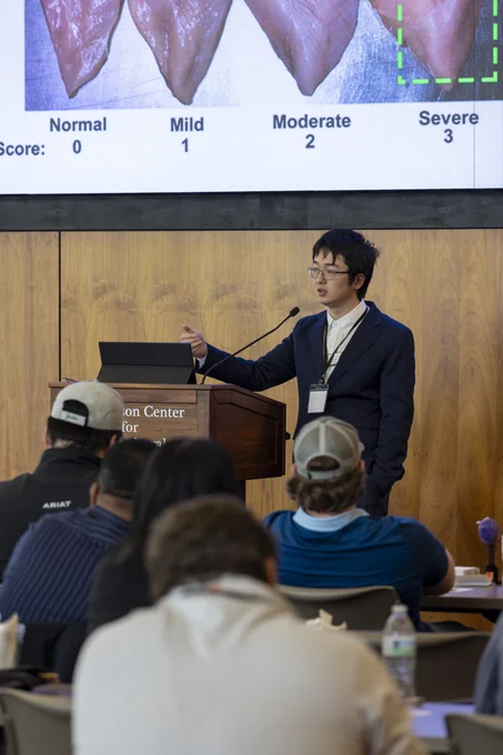 Dongyi Wang speaking at podium