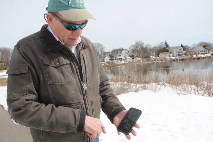 Joe Orchardo shows a photo he uploaded to the MyCoast app of flooding in his neighborhood.