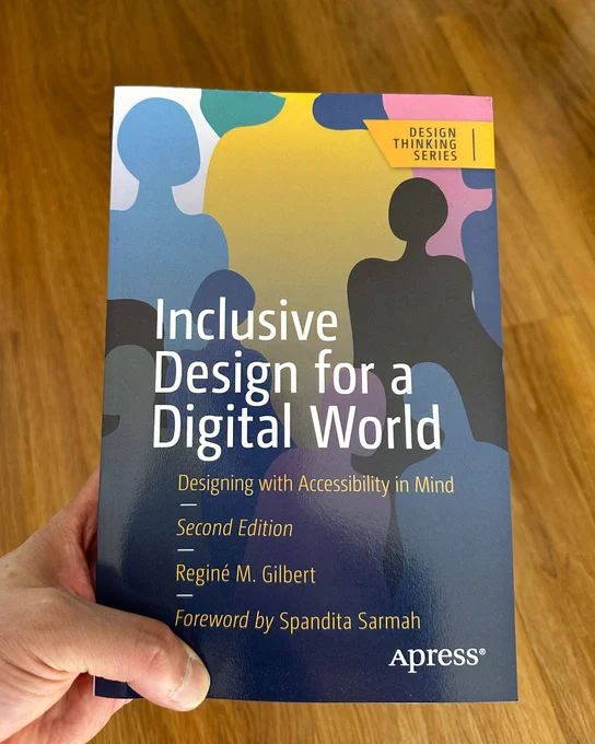 ID: "Image of me holding the book a copy of 'Inclusive Design for a Digital World, Designing with Accessibility in Mind, Second Edition, Foreward by Spandita Sarmah, Apress®'"