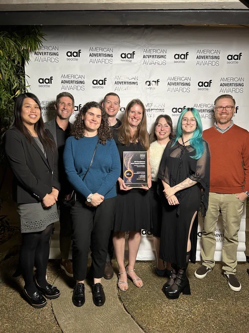 UW Continuum College Marketing Team with the Addy Award. From left to right: Rowena Clima, Bryan Chackel, Aubrey Hendryx, Dave Carulli,  Brenna Ciummo, Laura Bailey, Clara Garriga Dominguez and Joel Pitts