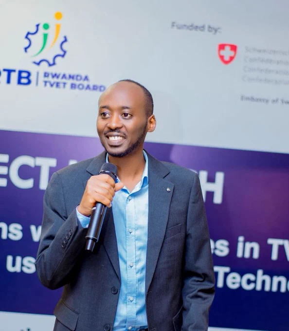 A man in a blue shirt speaks into a microphone