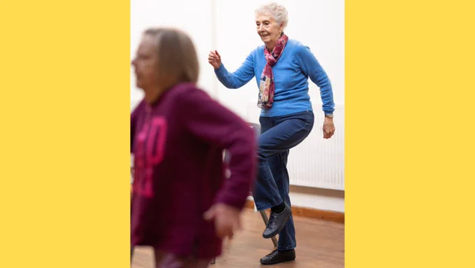 Two older people keeping active with simple exercise