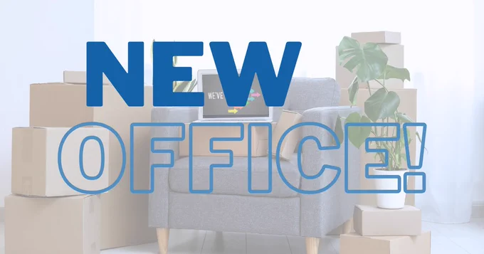 Gray armchair surrounded by stacked cardboard boxes and a green plant, with bold blue text announcing a new office.