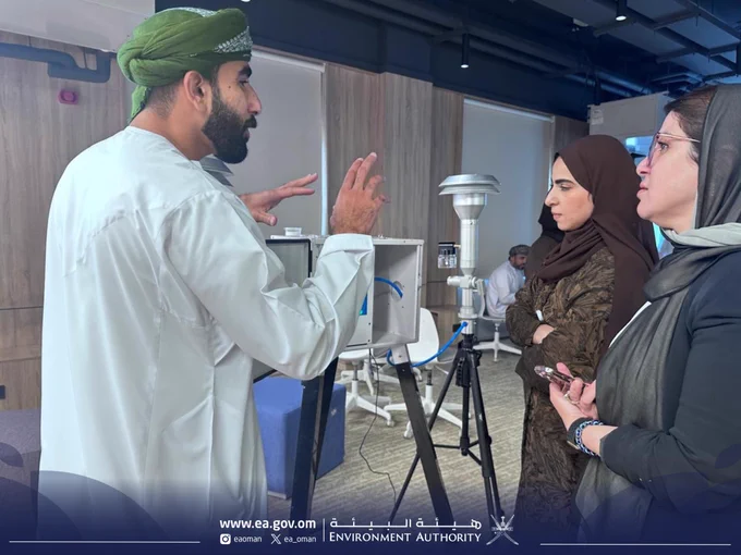 صورة لشخص يقدم شرحا عن جهاز بينما يركز الحضور  ويتابعون التفاصيل .