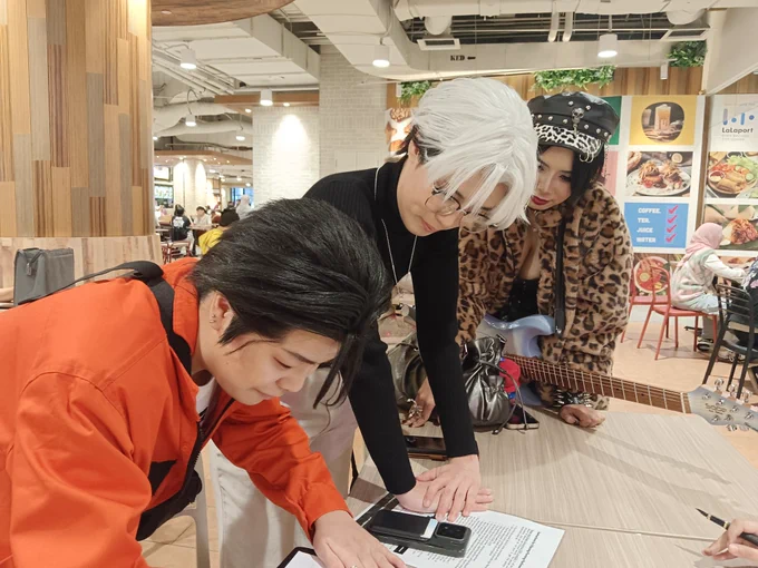 Cosplayers signing a petition 