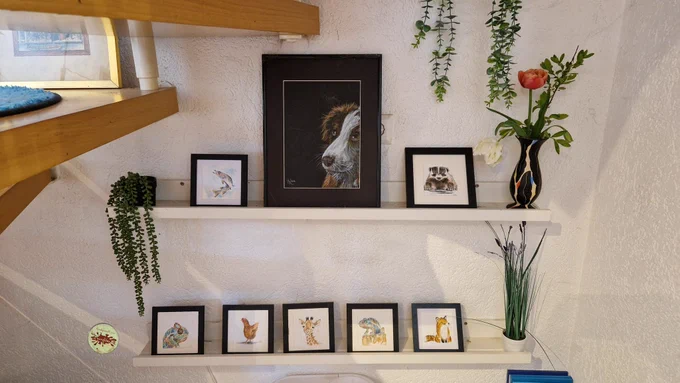 Auf zwei Borden aufgereiht sind 8 handgemalte Bilder, eins davon ein unverkäufliches Portrait meiner Hundedame , sowie kleine quadratische Bilder mit dem Motiv Dachs, Hecht, Giraffe, Huhn, 2x Chamäleon und Fuchs 