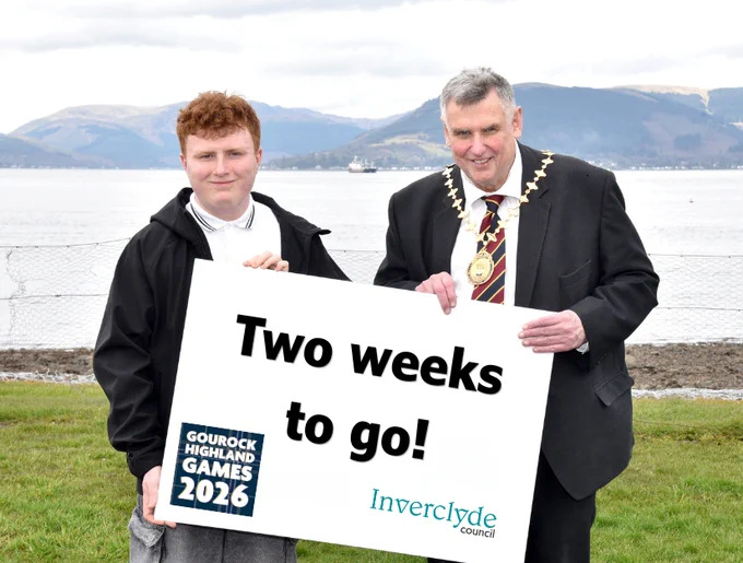 Cameron McGerr and Provost Drew McKenzie at Battery Park holding a sign announcing 'Two weeks to go!' for the Gourock Highland Games 2026 by Inverclyde Council.