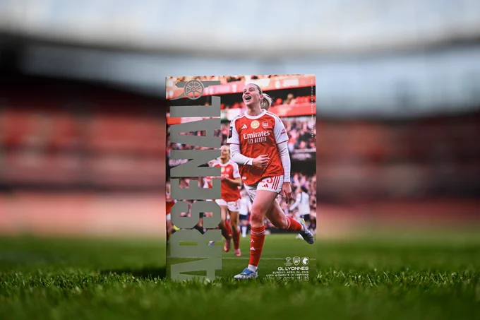 Today's programme positioned on the pitch at Emirates Stadium. The cover features a special silver foil banner for the UWCL and Alessia Russo celebrating a goal against Tottenham