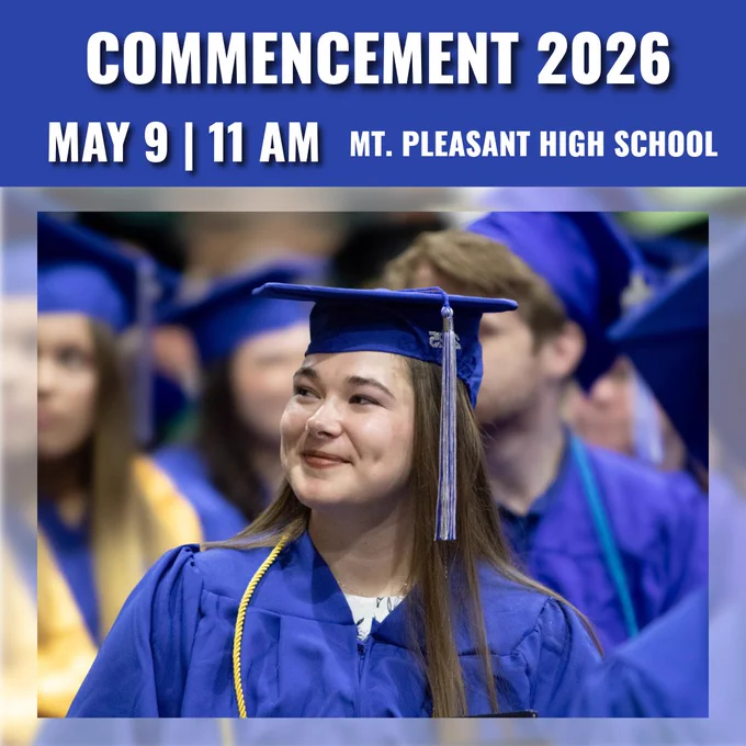 Student at graduation wearing a blue cap and gown, looking off to the left, smiling.