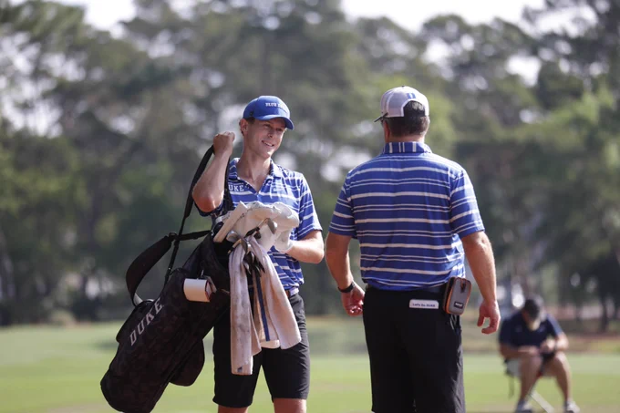 Ethan Evans pictured with golf bag, smiling. 