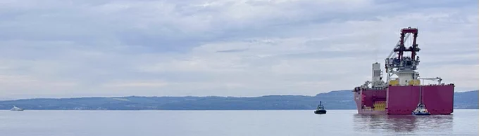 Luxury mega-yacht and installation vessel pass in the Forth.