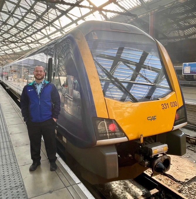 New conductor Adam in front of a train